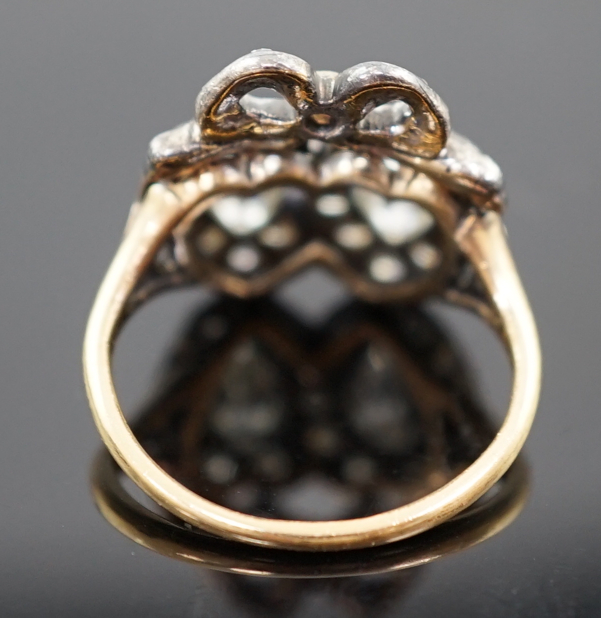 A 19th century gold, silver and diamond cluster set twin hearts ring, with ribbon bow surmounted